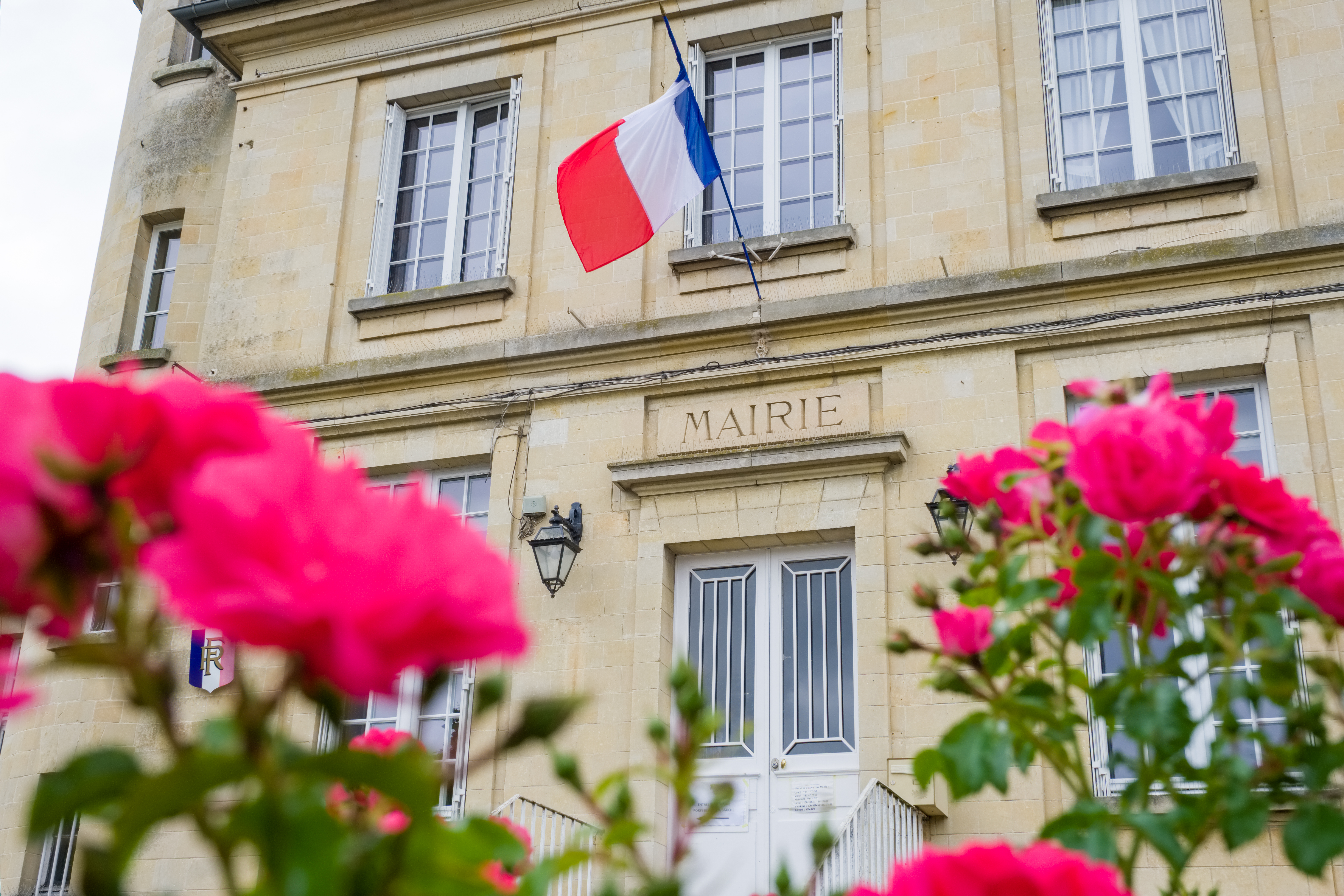 image de mairie avec le drapeau français et des fleurs à l'avant